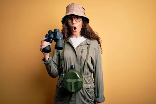 아름다운 여행사가 탐험가 모자를 쌍안경을 사용하여 표정으로 공포에 여행을 떠나고 — 스톡 사진
