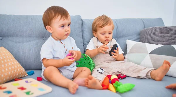 Kanepede Oturup Evde Oyuncaklarla Oynayan Güzel Bebekler — Stok fotoğraf