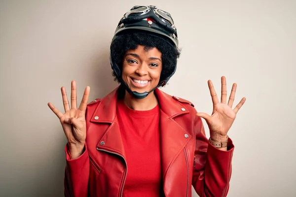 若いですアフリカ系アメリカ人アフリカ系アメリカ人オートバイの女性とともに巻き毛を身に着けていますオートバイヘルメットショーと指差しますと指数9とともに自信と幸せ — ストック写真
