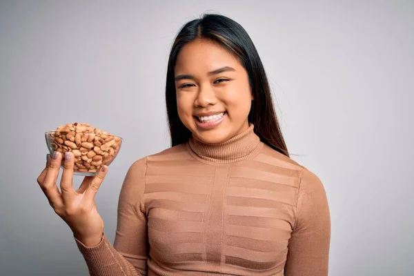 Genç Asyalı Kız Elinde Sağlıklı Fıstıklarla Besleniyor Beyaz Arka Planda — Stok fotoğraf