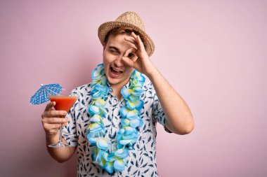 Tatilde olan, şapkalı, Hawaii 'li genç bir turist gülümseyen bir kokteyl içiyor.