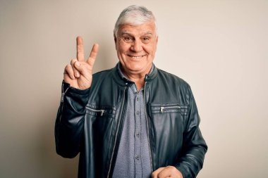 İzole edilmiş beyaz arka plan üzerinde günlük gömlek ve ceket giyen yaşlı yakışıklı adam kameraya bakıp gülümsüyor ve zafer işareti yapıyor. İki numara..