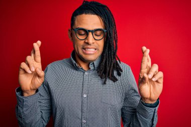 Rastgele gömlek ve gözlük takmış, umut ve gözlerin kapalı bir şekilde gülümseyerek el sallayan genç, Afro-Amerikan bir adam. Şans ve batıl inanç..