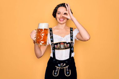 Mavi gözlü güzel Alman kadın geleneksel Ekim Festivali elbisesi giyiyor. Mutlu yüzlü bira kavanozu içiyor. Gülümsüyor.