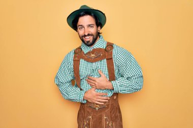 Almanya Festivali için geleneksel Alman Ekim Festivali kıyafeti giyen yakışıklı genç adam. Gülümsüyor ve kahkahalar atıyordu..