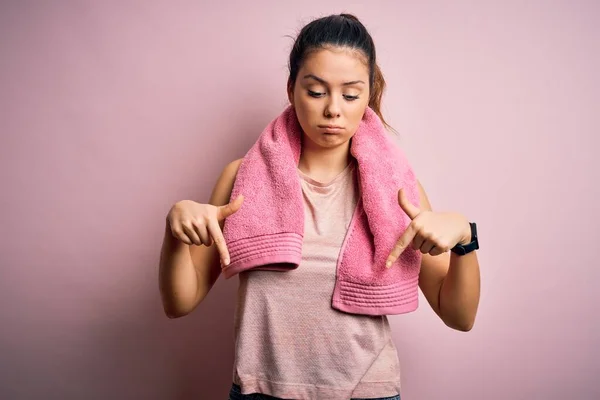 Young Beautiful Brunette Sportswoman Wearing Sportswear Towel Pink Background Pointing — Stock Photo, Image