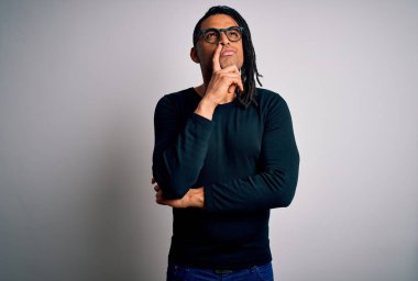 Rastgele tişört giyen, eli çenesinde gözlüklü soru soran, dalgın bir ifade takınan Afro-Amerikan genç yakışıklı adam. Düşünceli bir yüzle gülümsüyor. Şüphe kavramı.