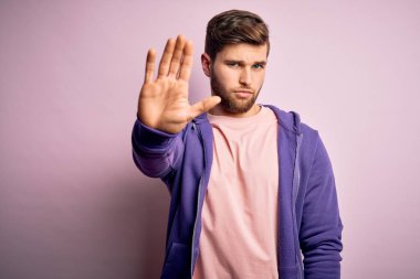 Sarışın, sakallı ve mavi gözlü pembe arka planda mor kazak giyen genç bir adam avucunun içi gibi şarkı söylemeyi kesiyor. Yüzünde olumsuz ve ciddi bir jest olan uyarı ifadesi.