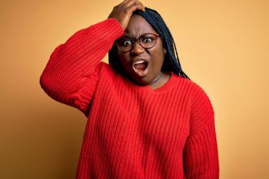 Sarı arka plan üzerine sıradan süveter giyen Afrikalı Amerikalı artı cüsseli bir kadın. Hatayla el ele tutuşurken şaşırdı. Hatayı hatırla. Unuttum, kötü hafıza konsepti.