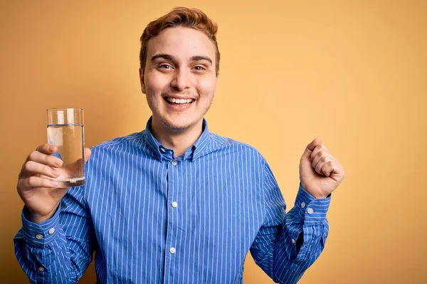 Ung Stilig Rödhårig Man Dricka Glas Vatten Över Isolerad Gul — Stockfoto