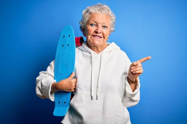 Senior Schöne Sportliche Frau Hält Schlittschuh Stehen Über Isolierten Blauen — Stockfoto