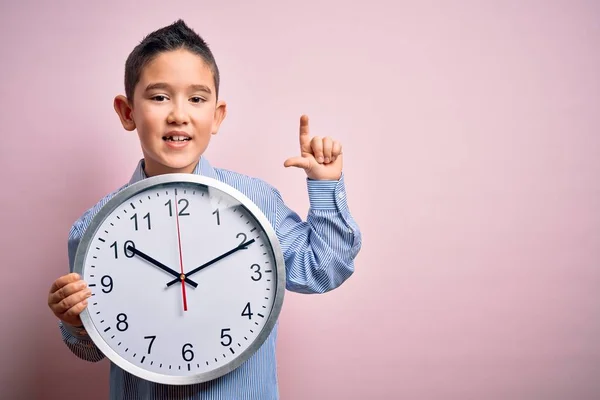 Niño Pequeño Sosteniendo Reloj Gran Minuto Sobre Fondo Rosa Aislado — Foto de Stock