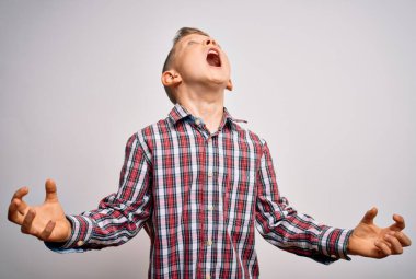 Mavi gözlü, genç beyaz bir çocuk izole edilmiş arka planda duran zarif bir gömlek giyiyor kızgın ve öfkeli çığlıklar atıyor, öfkeyle bağırıyor. Öfke ve agresif kavram.