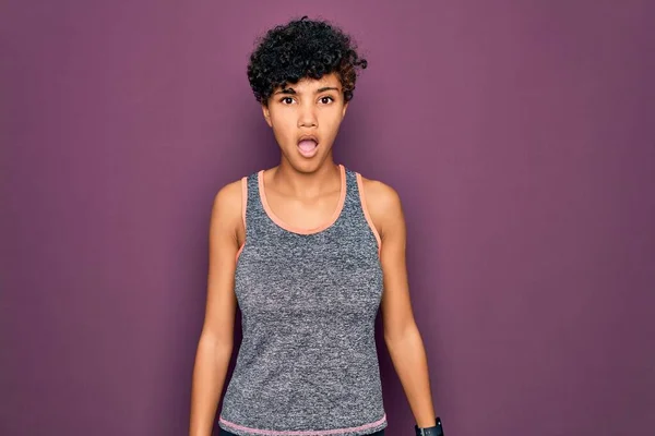 若い美しいアフリカ系アメリカ人のアフロスポーツ女性がスポーツウェアを着て運動をする衝撃的な顔で 懐疑的で皮肉そうに見え 口を開けて驚いて — ストック写真
