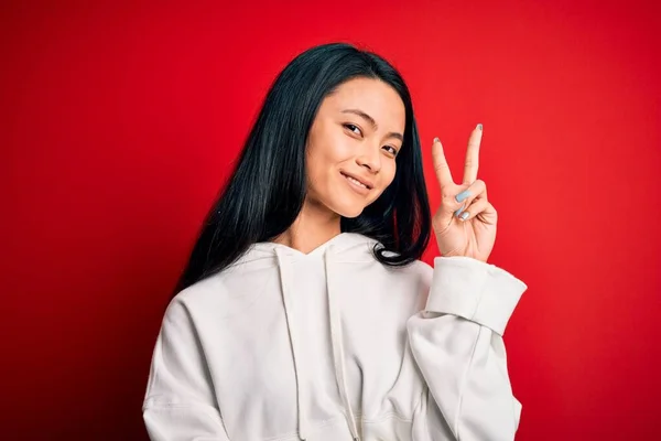 Jonge Mooie Chinese Sportieve Vrouw Draagt Sweatshirt Geïsoleerde Rode Achtergrond — Stockfoto