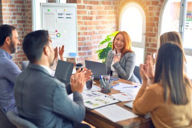 Group of business workers smiling happy and confident. Working together with smile on face applauding one of them at the office