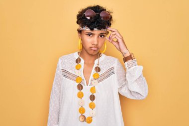 Güneş gözlüğü ve aksesuar takan Afro-Amerikan Afro-Amerikan genç bir kadın. Alnındaki sorun yüzünden endişeli ve stresli. Kriz için endişeli.