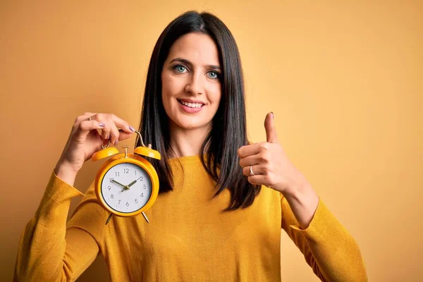 Ung Kvinna Med Blå Ögon Håller Väckarklocka Stående Över Isolerad — Stockfoto