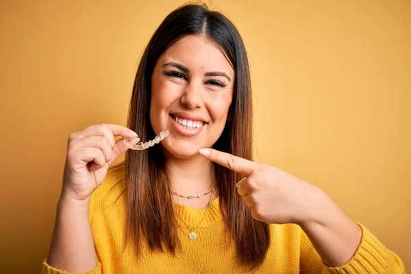 Young Beautiful Woman Holding Dental Orthodontic Aligner Corrector Yellow Background — Stock Photo, Image