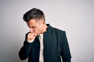 Soyutlanmış arka planda duran zarif kışlık ceketler giyen genç yakışıklı işadamları hasta hissediyorlar ve soğuk algınlığı veya bronşitin belirtisi olarak öksürüyorlar. Sağlık hizmeti kavramı.