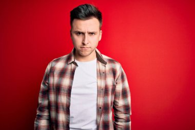 Genç, beyaz, gündelik modern tişörtler giyen, üzgün, üzgün, sinirli ve korkmuş bir adam. Üzücü ifade.