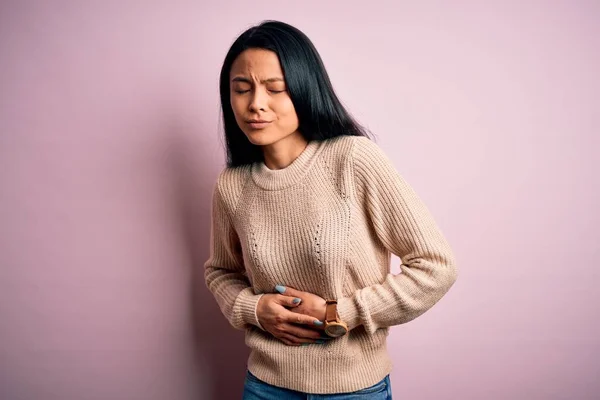 消化不良 痛みを伴う病気が体調不良のため 若い美しい中国の女性は胃の上に手で隔離されたピンクの背景にカジュアルなセーターを着て アチェの概念 — ストック写真