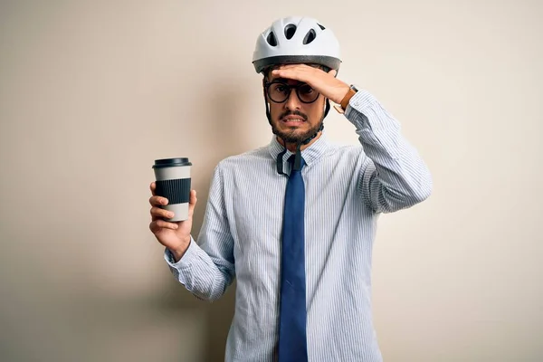 Young businessman wearing glasses and bike helmet drinking cup of coffee stressed with hand on head, shocked with shame and surprise face, angry and frustrated. Fear and upset for mistake.