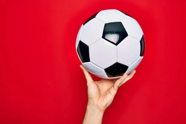 Bela Mão Homem Segurando Bola Futebol Sobre Fundo Vermelho Isolado — Fotografia de Stock