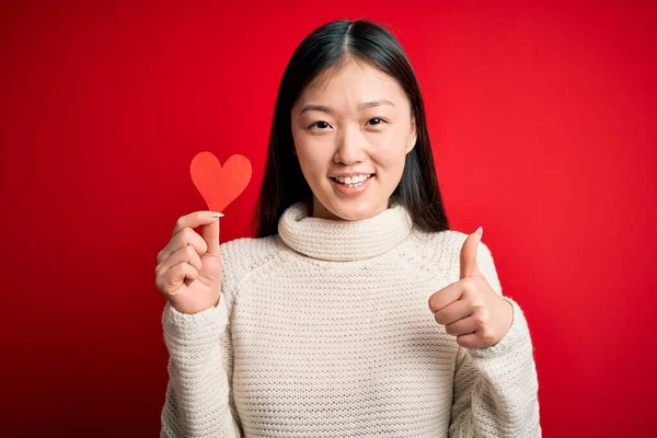 Junge Asiatische Frau Hält Romantische Rote Herzpapierform Über Roten Isolierten — Stockfoto