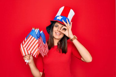 Amerika Birleşik Devletleri şapkası takan, güzel, vatansever bir kadın. Elinde bayraklar, mutlu mesut gülümsüyor.