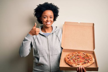 Kıvırcık saçlı, büyük gülümsemeli İtalyan pizzalı, kıvırcık saçlı, Afro-Amerikalı bir kadın.