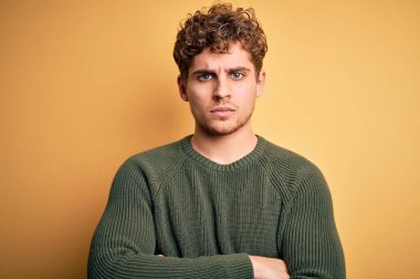 Sarışın, kıvırcık saçlı, sarı arka planda yeşil kazak giyen, kuşkucu ve gergin, yüzünde çapraz kollu tasvip etmeyen bir ifade olan genç, yakışıklı bir adam. Negatif kişi.