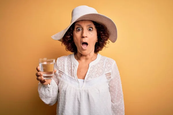 Middle Age Curly Woman Vacation Drinking Glass Water Isolated Yellow — Stock Photo, Image
