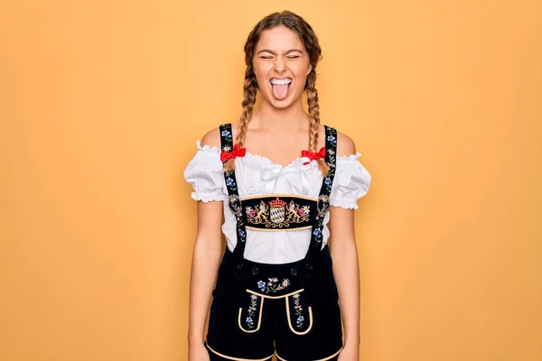 年轻美丽的金发德国女人 蓝眼睛 穿着传统的十月节礼服 带着滑稽的表情伸出舌头 情感概念 — 图库照片