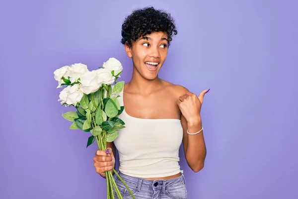 Красива Афроамериканка Тримає Букет Білих Квітів Над Фіолетовим Тлом Вказуючи — стокове фото