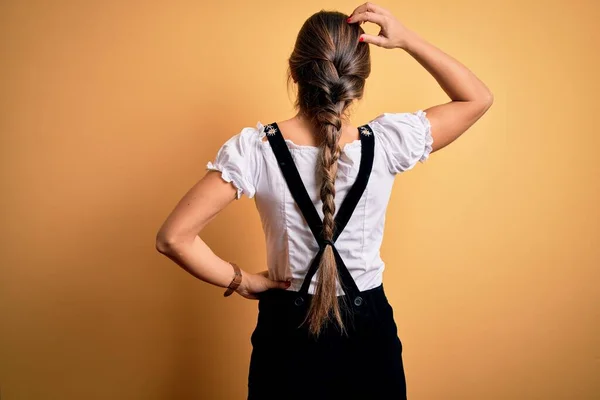 年轻美丽的黑发德国女人穿着传统服装庆祝10月的节日背对着怀疑 手牵着手思考 — 图库照片