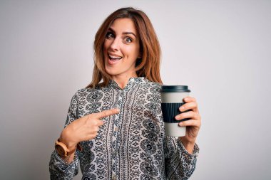 Genç, güzel esmer kadın beyaz arka planda bir bardak kahve içiyor. El ve parmak göstererek çok mutlu.