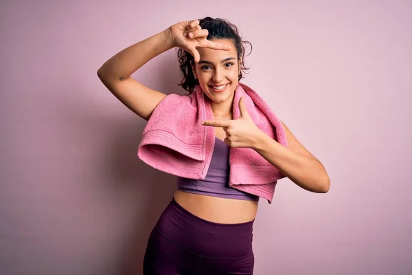 年轻美丽的女运动员 用毛巾披着粉红的背景做运动 微笑着用双手和手指做框架 笑容满面 创意和摄影概念 — 图库照片