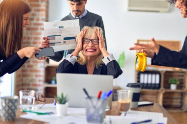 Group of business workers working together. Partners stressing one of them at the office