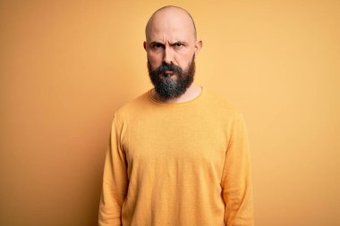 Sarışın, kel, sakallı, sıradan bir süveter giyen, sarı arka planda duran, şüpheci ve gergin, sorun yüzünden suratını asan yakışıklı bir adam. Negatif kişi.