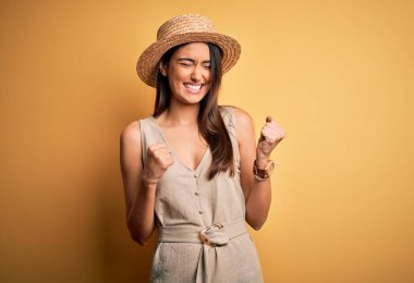 Genç, güzel, esmer, gündelik elbiseler giyen, şapkalı, kolları havada, gözleri kapalı zaferi kutlayan genç bir kadın. Kazanan konsept.