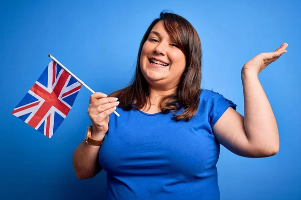 Güzel Büyük Kadın Mavi Arka Planda Birleşik Krallık Bayrağını Tutuyor — Stok fotoğraf