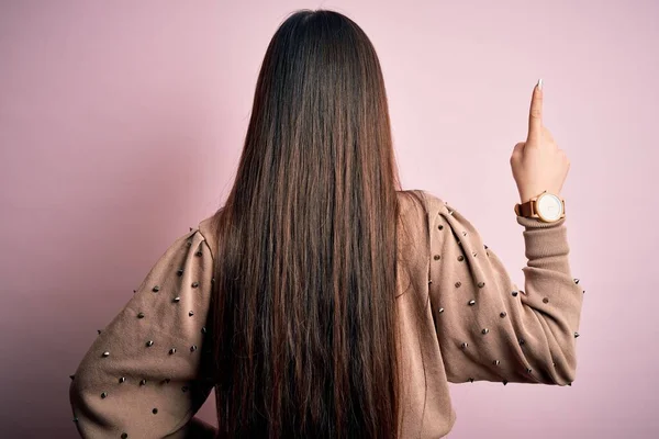 年轻美丽的亚洲女人 穿着时尚和典雅的毛衣 披着粉色的帆布衬托 背对着前方 手拿着手指头 — 图库照片