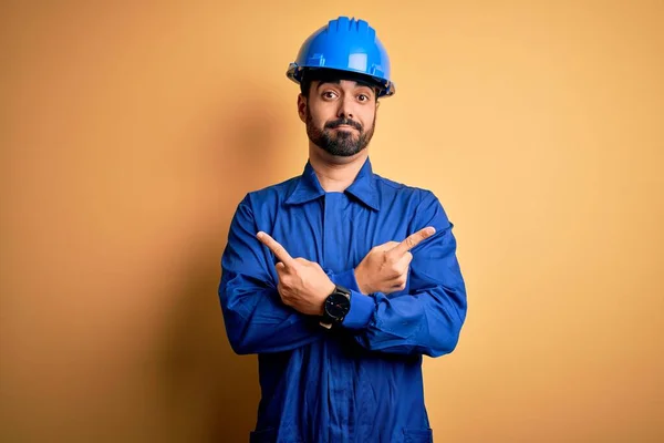 Mechaniker Mit Bart Trägt Blaue Uniform Und Schutzhelm Über Gelbem — Stockfoto