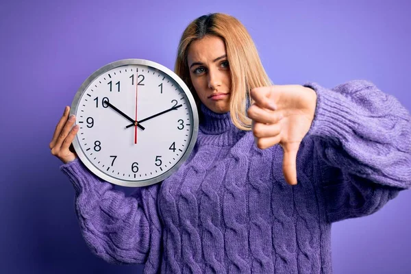 Young Beautiful Blonde Woman Doing Countdown Holding Big Clock Purple — Stock Photo, Image