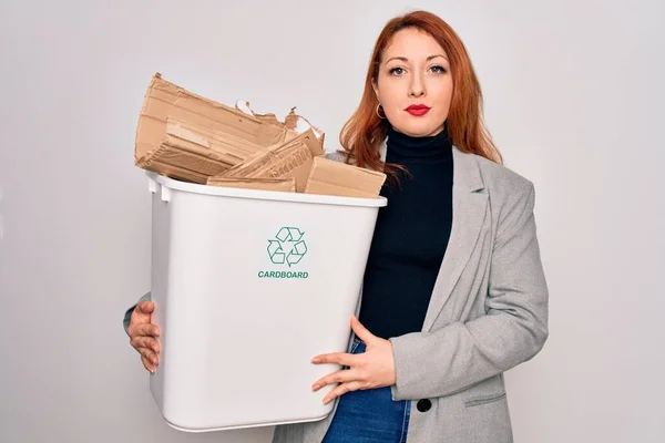 若い美しい赤毛の女性は真剣に考えてスマート顔に自信を持って式でリサイクルする段ボールでゴミ箱を保持リサイクルすることができます — ストック写真