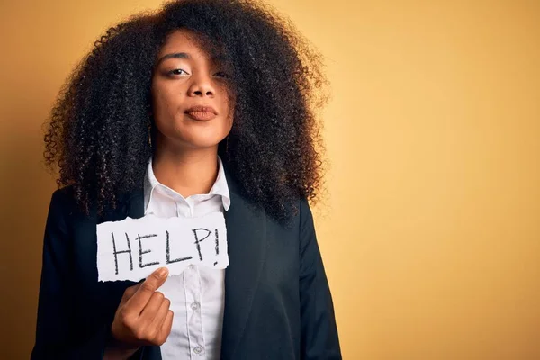 Young african american business woman with afro hair holding help paper for work stress with a confident expression on smart face thinking serious