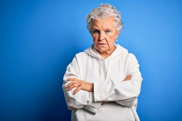 Starsza Piękna Sportowa Kobieta Białej Bluzie Odizolowanym Niebieskim Tle Sceptyczna — Zdjęcie stockowe
