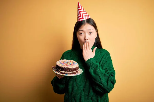 Jovem Asiática Segurando Bolo Aniversário Vestindo Chapéu Festa Sobre Amarelo — Fotografia de Stock