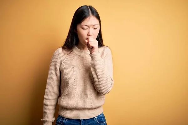 年轻美丽的亚洲女人穿着休闲衫 披着黄色孤立的背景 感觉不适 咳嗽是感冒或支气管炎的症状 保健概念 — 图库照片